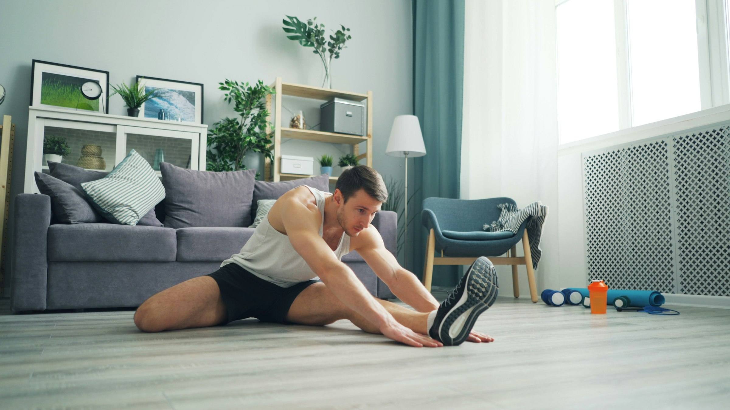 A man stretching on the floor of his living room