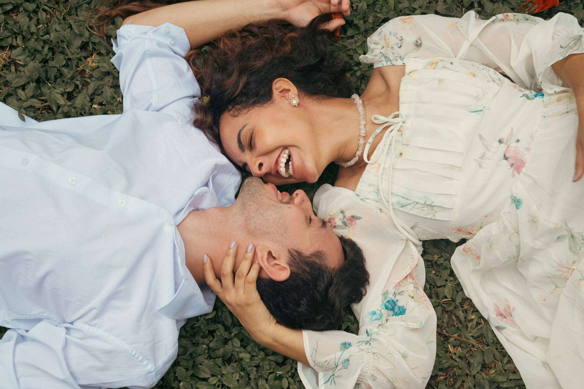 A couple lying on the grass, laughing together