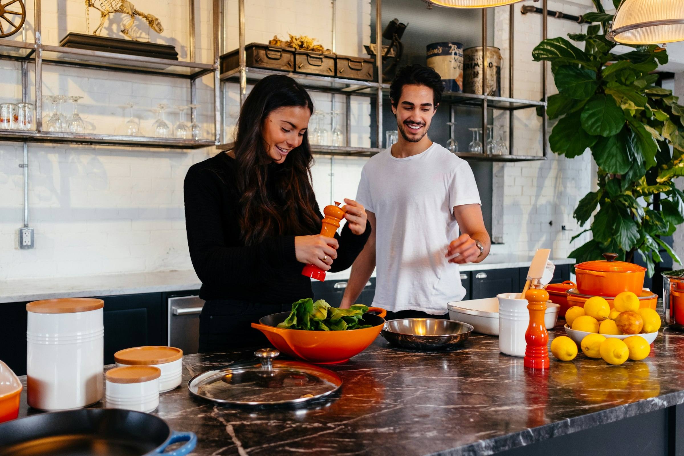 A couple cooking a fresh meal together in a bright kitchen